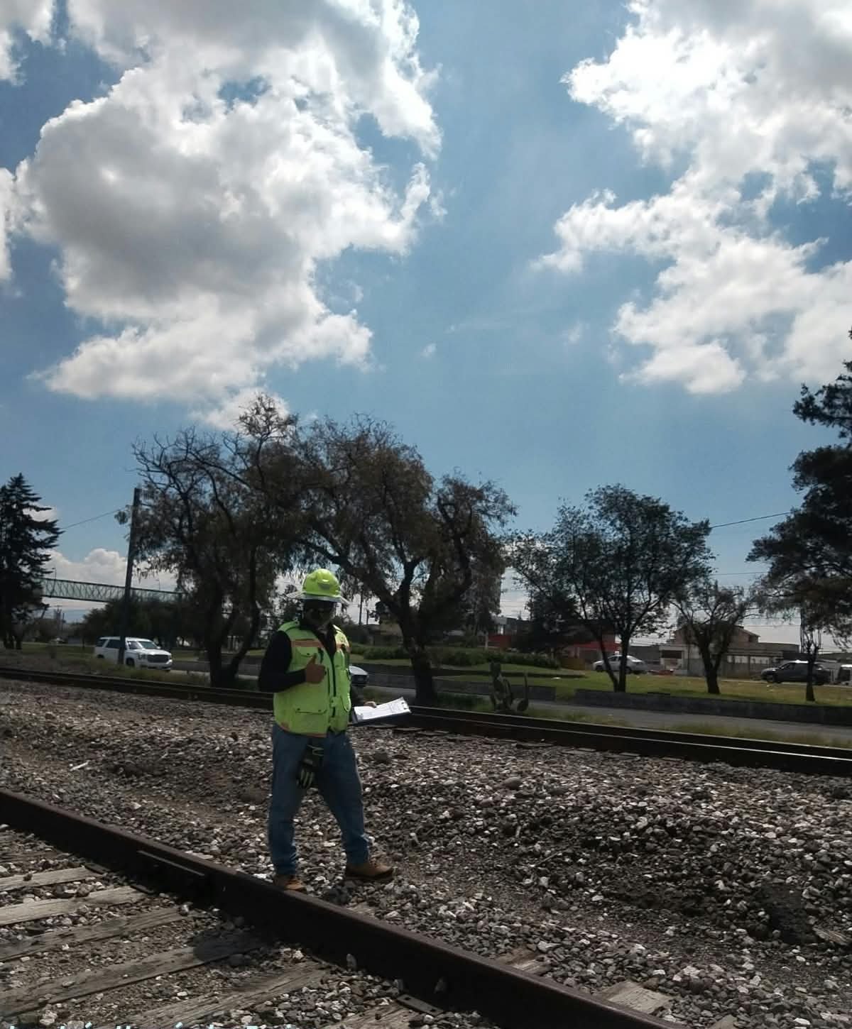 Profesional realizando supervisión técnica junto a vías ferroviarias